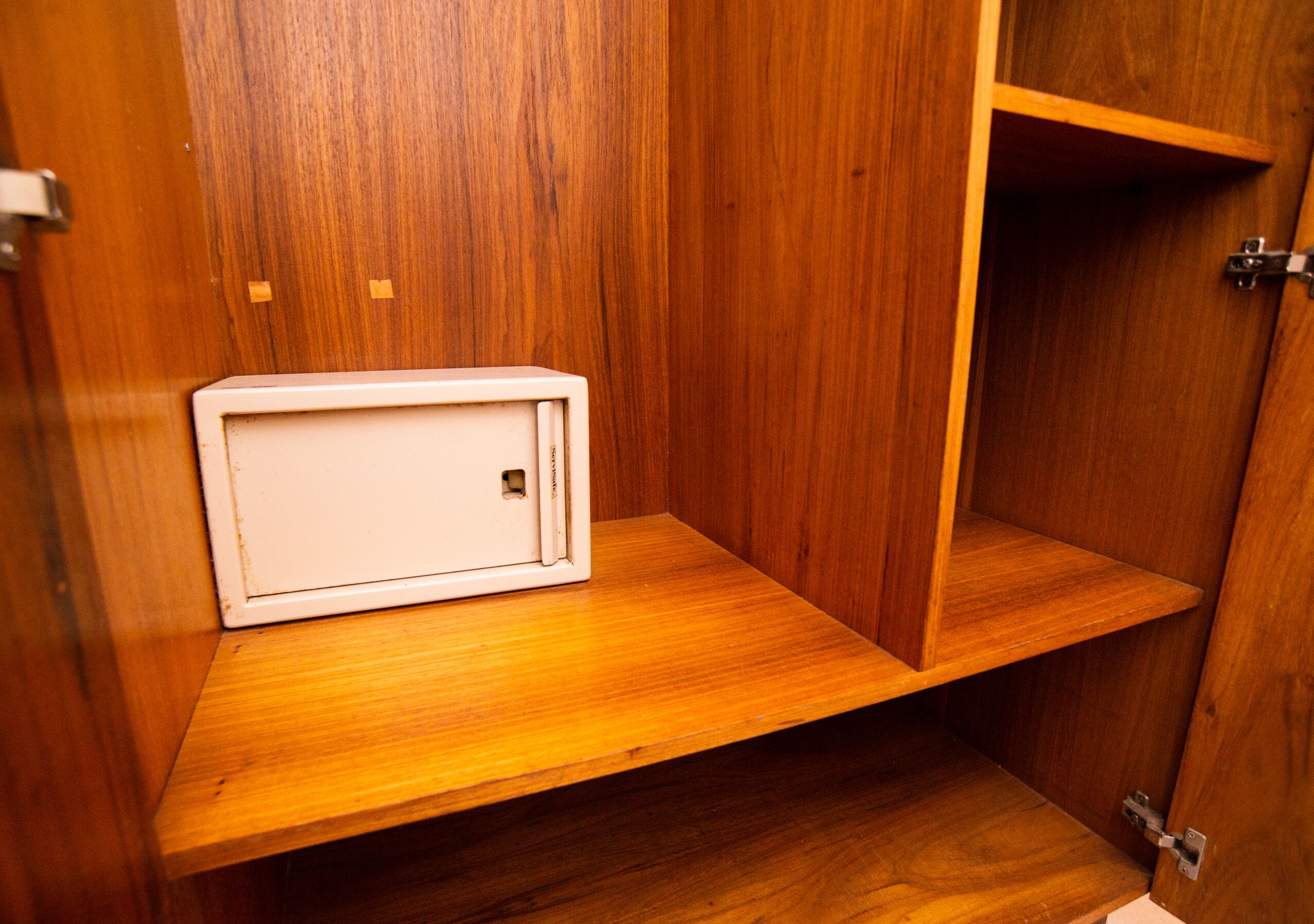 Un meuble en bois sur lequel est posé un appareil électroménager blanc, peut-être un four à micro-ondes.