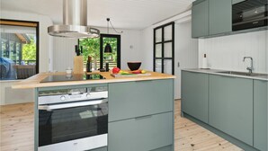 Una cocina moderna con una isla central, horno empotrado y campana extractora Siemens.