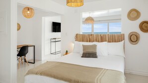 A modern bedroom with a large bed, a desk, and a TV. - Cocovaa (Simpson Bay)
