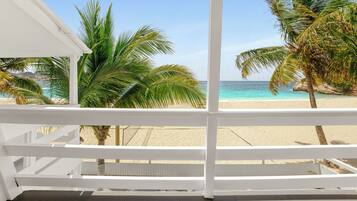 Un balcon avec vue sur une plage et des palmiers.