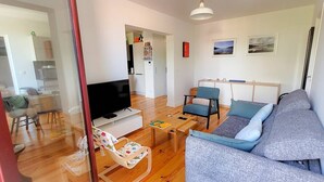 A living room with a sofa, chairs, a TV, and a wooden coffee table. - La riviéra" apartment. (HOSSEGOR)