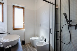 Een douche, een haardroger, een bidet, handdoeken