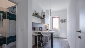 A modern kitchen with a central island, bar stools, and a window with a view.