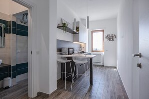 A modern kitchen with a central island, bar stools, and a window with a view. - Comfortable apartment with little balcony, furnished with taste and perfect for two people. The accommodation is located in a very convenient position: outside the ZTL but at the same time a few steps from the historic centre, reachable on foot in five m (Lecce)