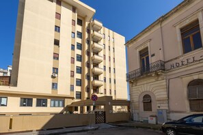 A tall beige building with multiple balconies and a sign indicating a hotel. - Comfortable apartment with little balcony, furnished with taste and perfect for two people. The accommodation is located in a very convenient position: outside the ZTL but at the same time a few steps from the historic centre, reachable on foot in five m (Lecce)