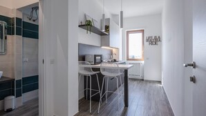 A modern kitchen with a central island, bar stools, and a window with a view.