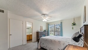 A bedroom with a bed, a desk, a ceiling fan, a window, and a dresser. - The Lake Escape @Brownwood (Brownwood)