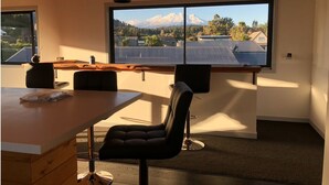 A modern room with a large window offering a view of a mountain and a cityscape.
