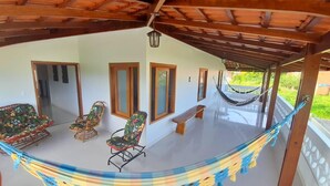 A covered patio with a hammock, wicker chairs, and a bench. - CASA VIVA MILAGRES (São Miguel dos Milagres)