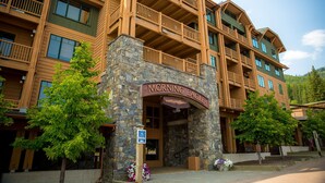 A multi-story hotel with a stone facade and wooden balconies. - Freshly updated 3 bedroom ski in and out Morning Eagle condo (Whitefish)