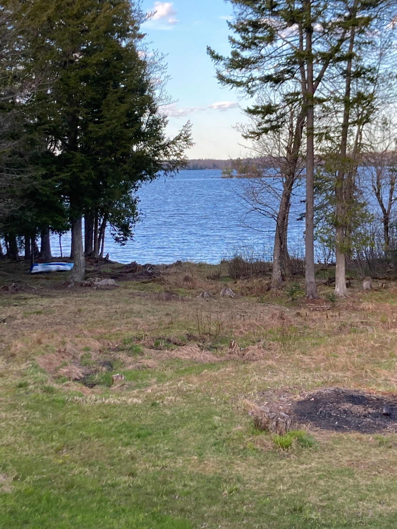 Un paysage naturel comprenant un lac, des arbres et des zones herbeuses.