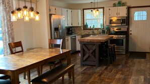 Una cocina amplia con suelo de madera, una isla central y electrodomésticos modernos.