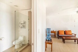 A modern bathroom with a glass-enclosed shower, a toilet, and a water dispenser. - Ocean Views and Sounds · Walk to Beach · Surf · Pool (Cóbano)