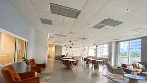 A spacious office with modern furniture, large windows, and a clean, open layout.