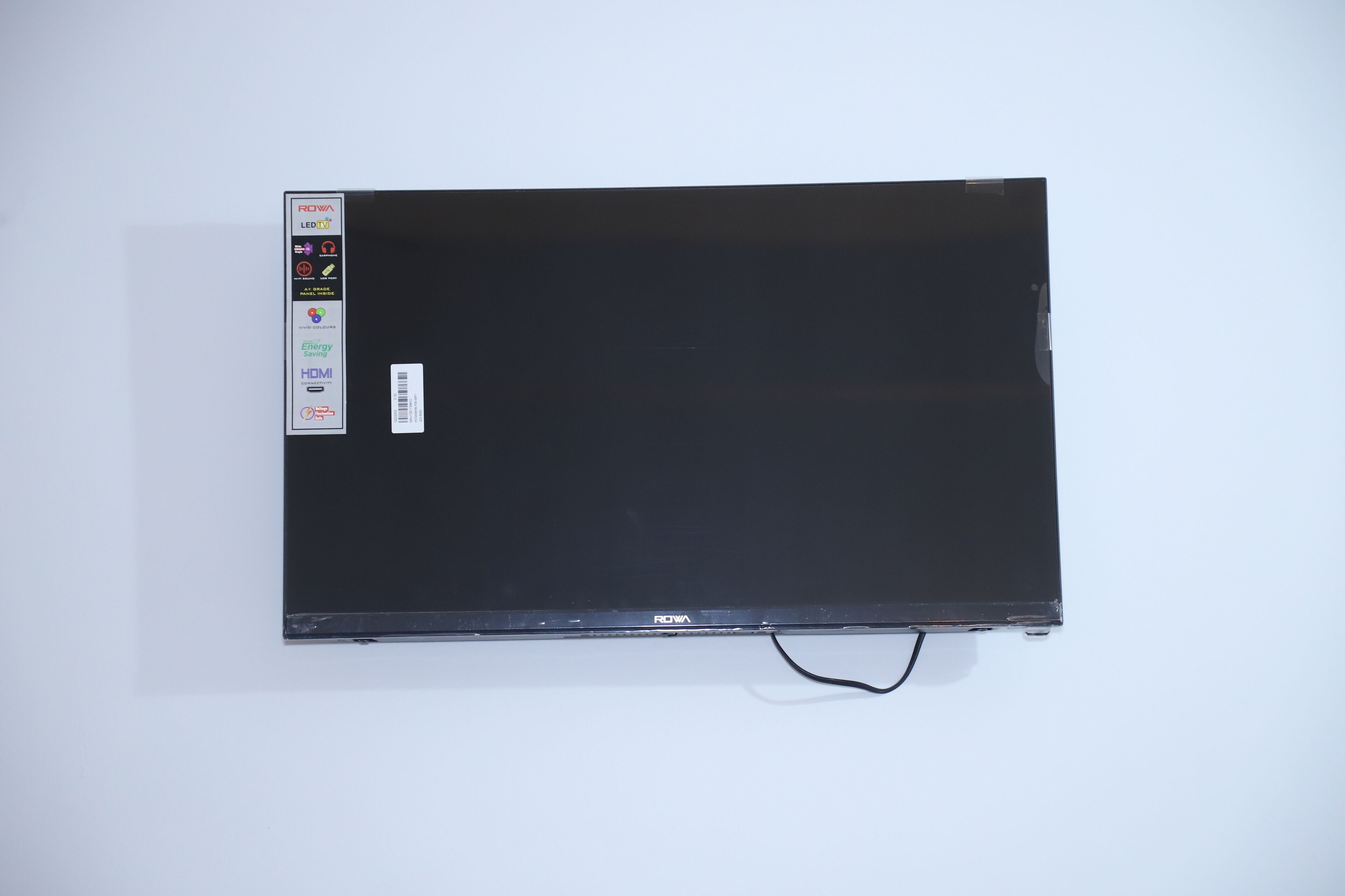 Una televisione a schermo piatto con un'etichetta identificativa del marchio e un'adesivo con codice a barre.