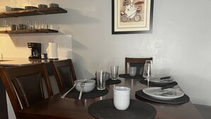 A dining table set with plates, bowls, glasses, and cutlery.