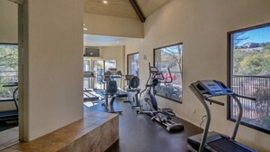 A gym with treadmills, stationary bikes, and elliptical machines.