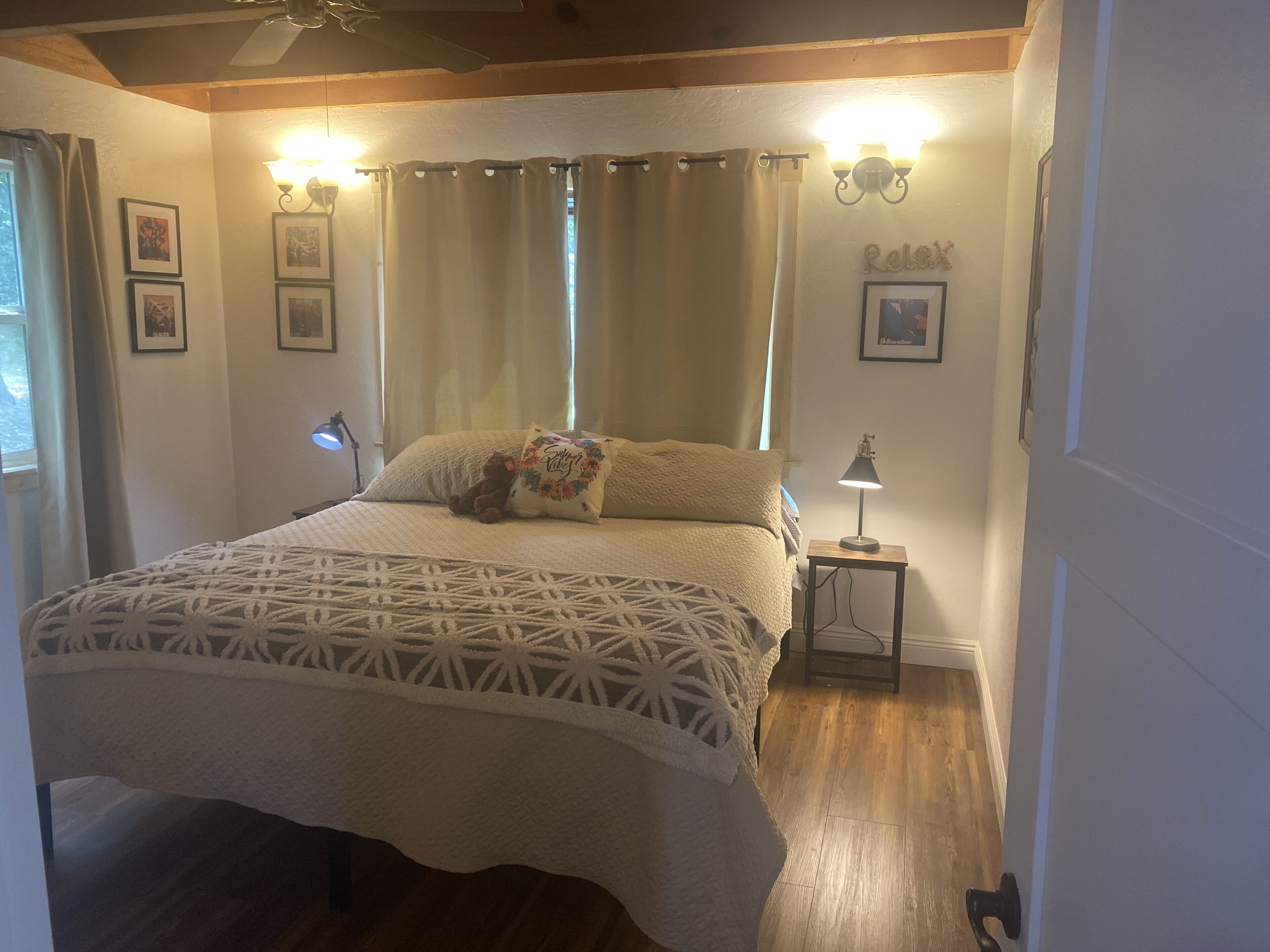 Une chambre à coucher avec un lit, une table de chevet, une lampe et un ventilateur de plafond.