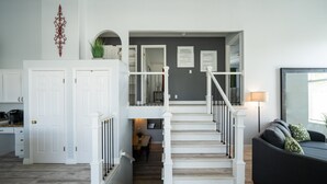 A staircase leading to a second floor with a dining area below.