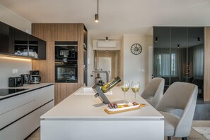 Enjoy a casual dining experience in this stylish kitchen and dining area, featuring a central island, oven, and comfortable seating.
