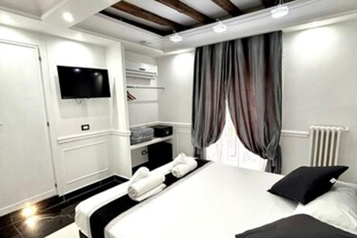 Quarto moderno com uma cama grande, televisão de tela plana na parede e armário embutido.