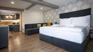 Une chambre d’hôtel moderne équipée d’un grand lit, d’un canapé, d’un bureau et d’une kitchenette.