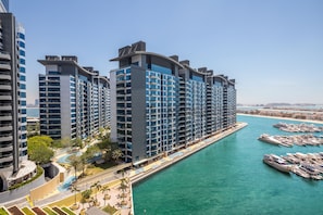 Ein Hochhaus-Hotel mit mehreren Balkonen und einem Hafen voller Boote.