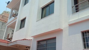 A multi-story building with balconies, air conditioning units, and potted plants. - Janaki House (Burhanilkantha)