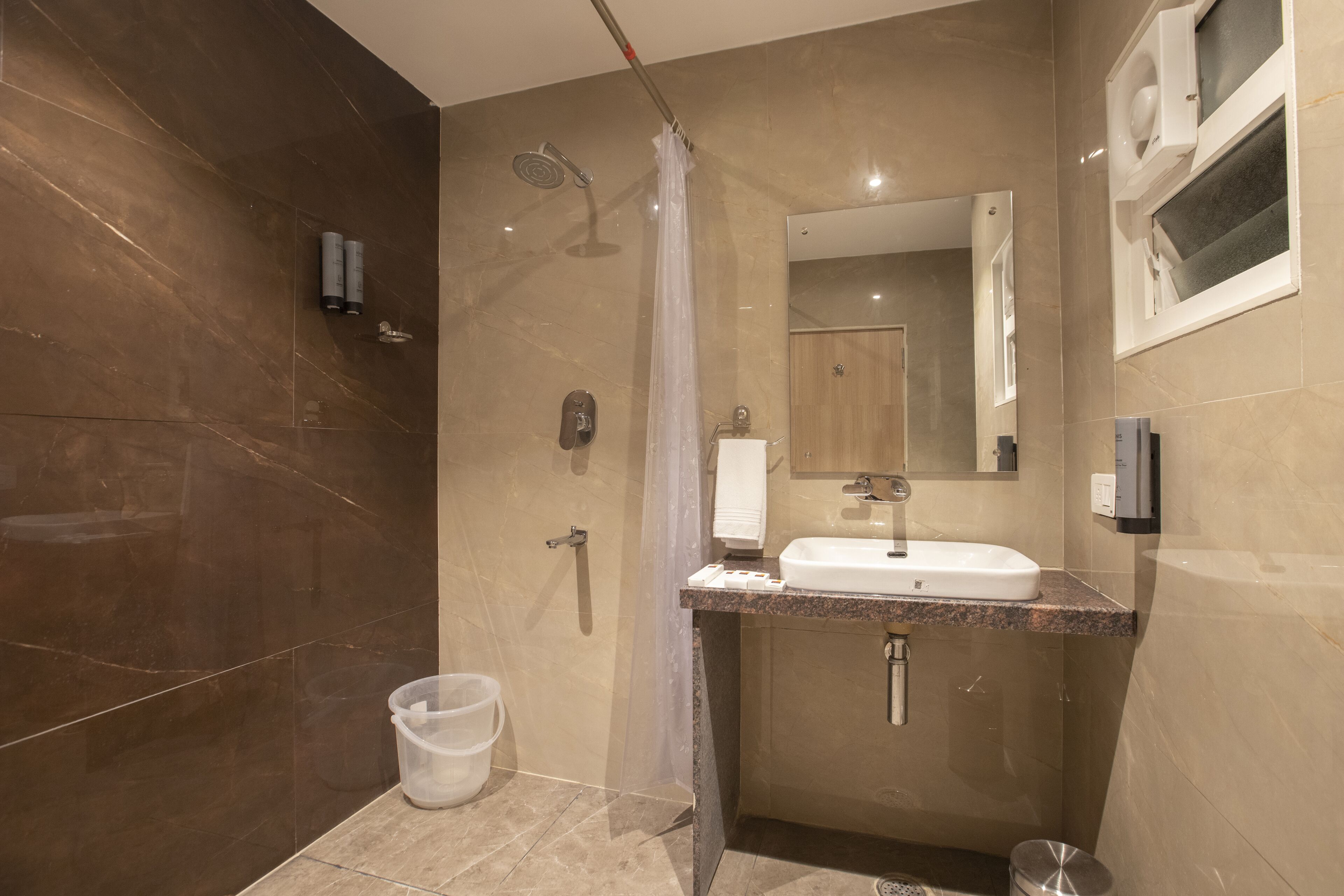 A modern bathroom with a shower, a sink, and a mirror.