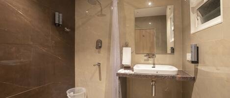 Une salle de bain moderne avec une douche, un lavabo et un miroir.