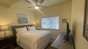 A bedroom with a bed, a desk, a ceiling fan, a window with blinds, and a painting on the wall. - Ultimate Beach Vacation in the Heart of Carlsbad  (Carlsbad)