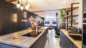 A modern kitchen with a central island, pendant lighting, and a view into the dining area. - Gorgeous home in Roermond with kitchen (Roermond)