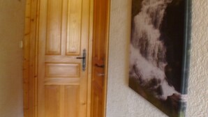 En dörr av trä med ett handtag och ett nyckelhål, placerad intill en vägg med en strukturerad yta.