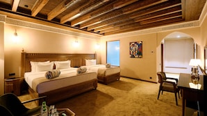 A hotel room with two beds, a desk, and a chair. - Kosh Havuz Boutiqe Hotel (Samarkand)