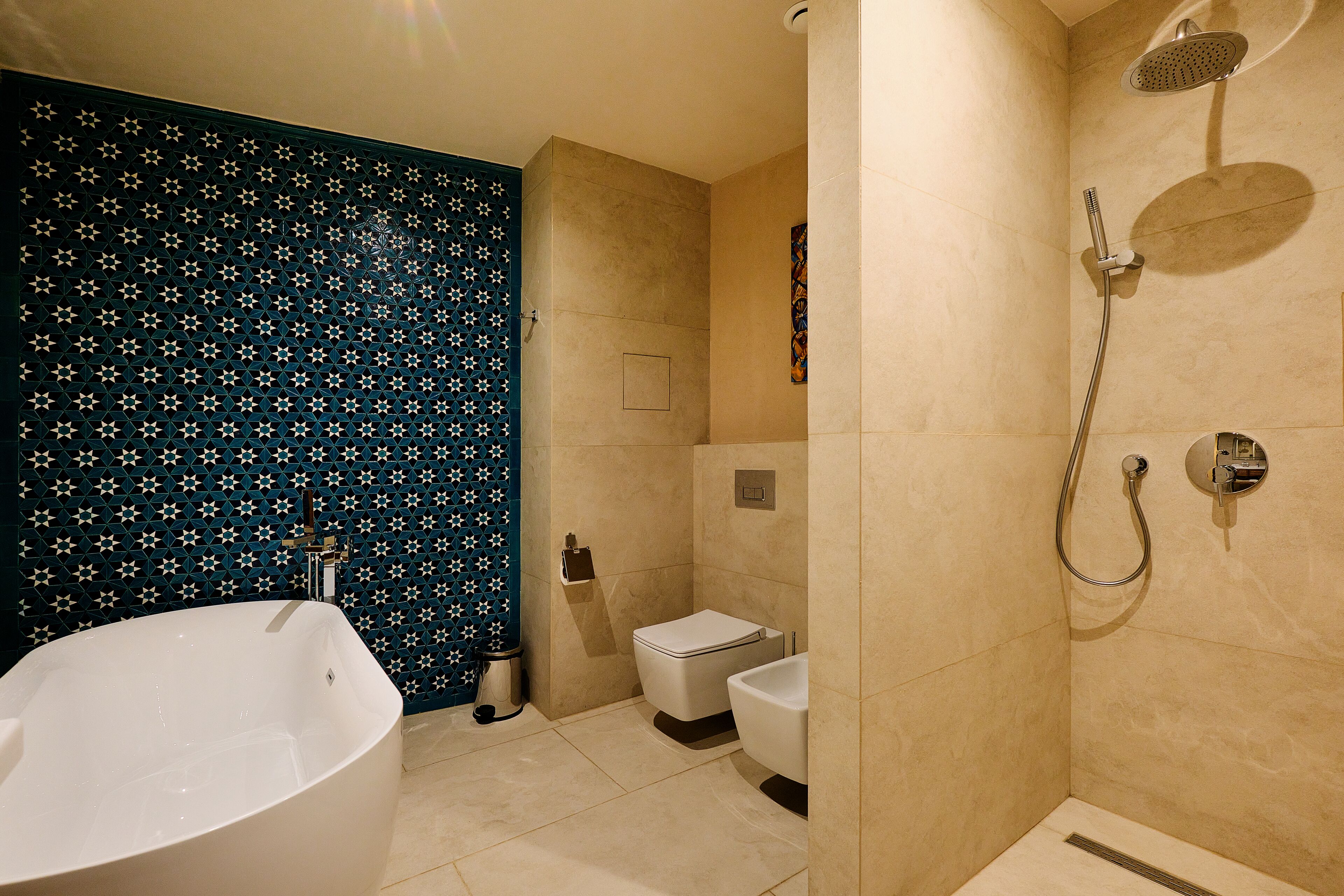 Een badkamer met een vrijstaand bad, een toilet en een douchehoek.