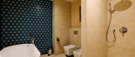 Un bagno con una vasca freestanding, un water e uno spazio doccia.
