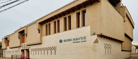A building with a sign reading "KOSH HAVUZ boutique hotel".