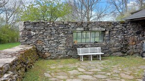 A stone wall with a window and a white bench in front. - Proche Laguiole - Maison au Calme - vue Imprenable (Curières)