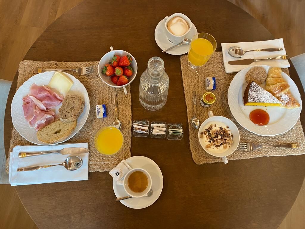 Un plateau de petit-déjeuner avec des croissants, des fraises, du fromage et du café.