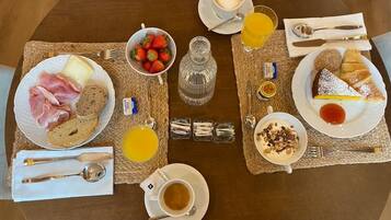 Un plateau de petit-déjeuner avec des croissants, des fraises, du fromage et du café.