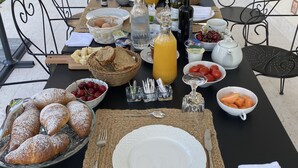 A breakfast table set outdoors with various food items and drinks. - CasaOssan (San Pietro in Cariano)