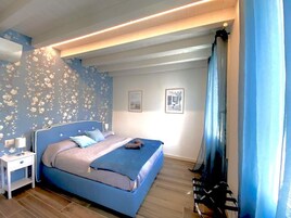 Un dormitorio con cama, mesita de noche y decoración en la pared.