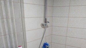 Une salle de bain équipée de toilettes, d’une douche et de divers produits de toilette disposés sur le lavabo.