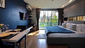 A modern hotel room with a large bed, a desk, and a TV. - Vacation Home Rental The Starhill Condo Chiang Mai (Muang Chiangmai)