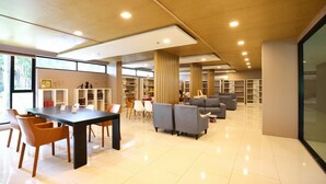 A modern interior with a dining area, sofas, and bookshelves. - Vacation Home Rental The Starhill Condo Chiang Mai (Muang Chiangmai)