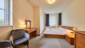 Une chambre d’hôtel avec un lit, un bureau, une chaise et une fenêtre.