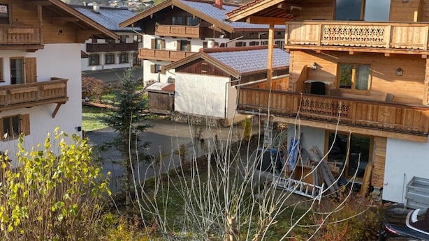 A traditional wooden chalet with a balcony, surrounded by a mountainous landscape. - Ferienwohnung Kaiserin (Reit im Winkl)
