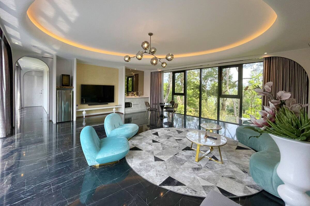 A modern living room with a large TV, a round coffee table, and two sofas.