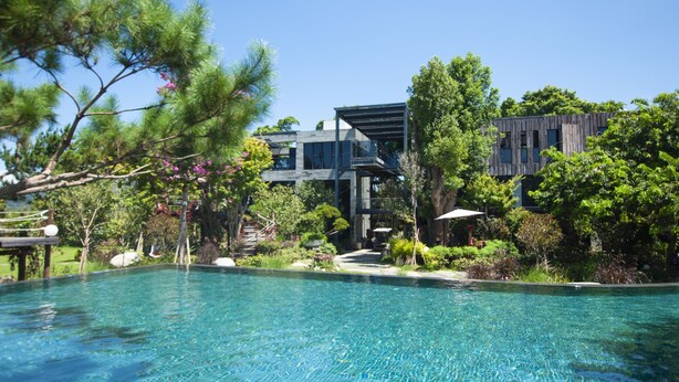 A modern pool area with clear blue water, surrounded by lush greenery and contemporary architecture. - The Forest Museum (Zhuolan)