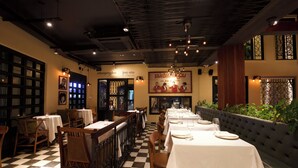 Un restaurante con suelo a cuadros, muebles de madera y manteles blancos.